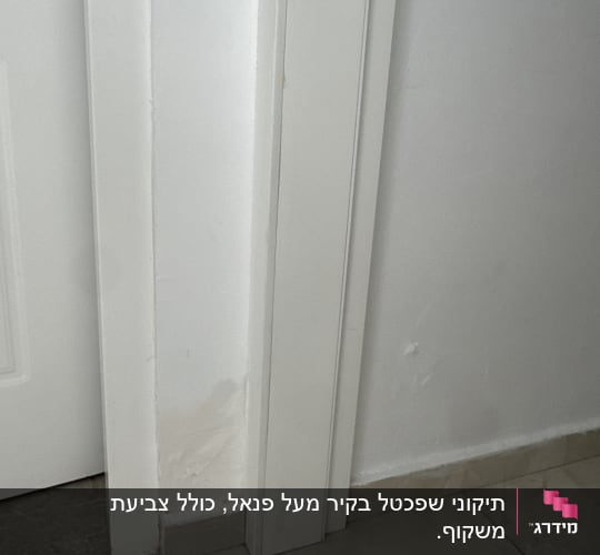 דלת לבנה עם קיר צבוע חלקית ליד הרצפה